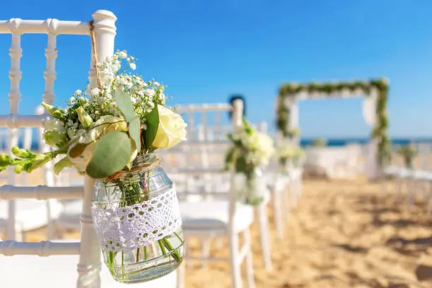 Fotografía de una recepción de boda en un viñedo pintoresco al atardecer, con mesas decoradas con luces centelleantes y vistas impresionantes de las filas de viñas, destacando la belleza y el encanto de las bodas al aire libre en la naturaleza.